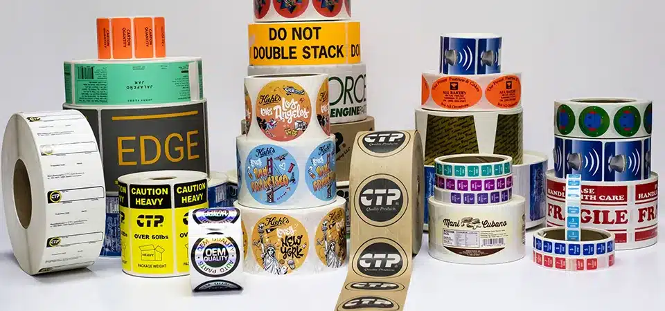 A roll of custom-printed product labels next to a stack of professionally packaged boxes