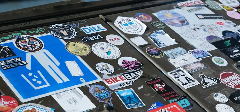 A graphic designer inspecting a sticker's cutline and bleed on a computer monitor