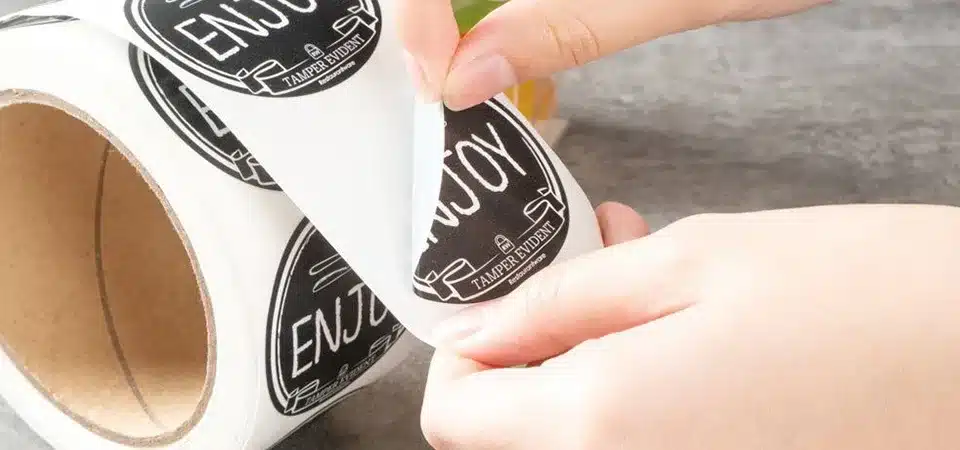 A diagram showing the layers of a waterproof sticker: laminate, ink, polypropylene material, and adhesive
